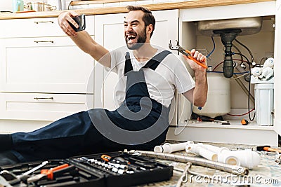 Man plumber work in uniform indoors take a selfie Stock Photo