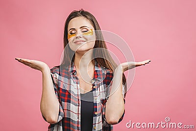 Image of young pure beautiful gentle woman isolated, take care of her skin with under eye golden patches Stock Photo