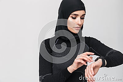 Young woman fitness muslim using watch clock isolated over white wall background Stock Photo