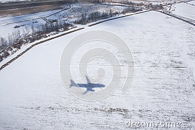 Black shadow from airplane on snowy field Stock Photo