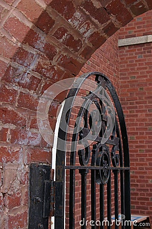 A Metal Gate Guards The Entry to a Brick Courtyard Stock Photo