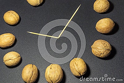 Imitation of a walnut clock fragment on a black background Stock Photo