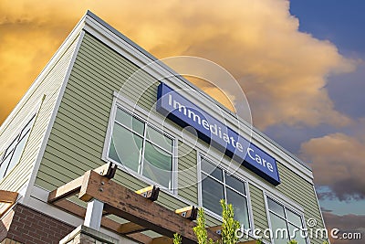 Immediate Care Sign On Hospital Building with Clouds Stock Photo