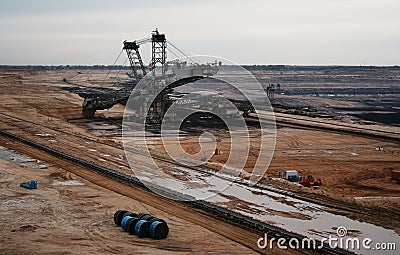 Immense brown coal excavator in an opencast mine in the foreground of a vast, sprawling landscape Editorial Stock Photo