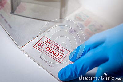 Immigration officer push negative covid-19 test stamp in tourist passport Stock Photo