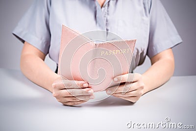 Immigration and passport control at the airport. woman border control officer with passport in the pink cover. Concept. Stock Photo