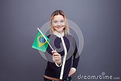 Immigration and the study of foreign languages, concept. A young smiling woman with a Brazil flag in her hand. Stock Photo