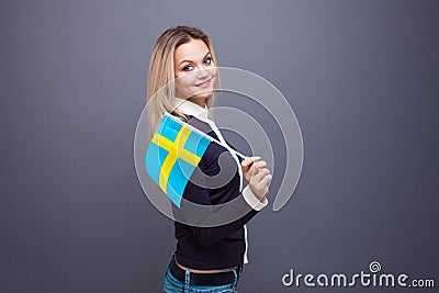 Immigration and the study of foreign languages, concept. A young smiling woman with a Sweden flag in her hand. Stock Photo