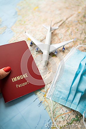 Immune passport travel theme. Woman hand with red nails holding vaccinated document Stock Photo