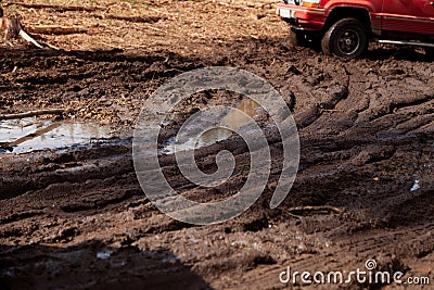 Impassable dirt on the road, an obstacle for a car on a forest road, a blurred ground under the wheel of a car Stock Photo