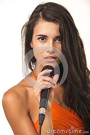 Impassioned girl in orange shirt with microphone. Stock Photo