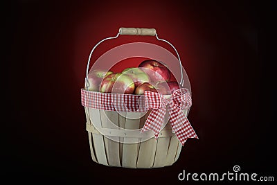 Imperfect apples basket isolated on black and red Stock Photo