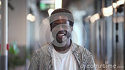 Impiegato di un allenatore d'affari di colore sorridente che guarda la telecamera in ufficio video d archivio Impiegato di un allenatore d'affari di colore sorridente che guarda la telecamera in ufficio video d archivio