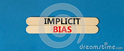 Implicit bias symbol. Concept words Implicit bias on wooden sticks. Beautiful blue table blue background. Business psychology Stock Photo