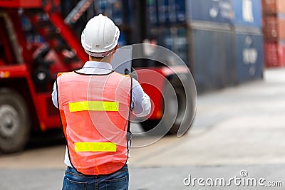 Import and export concept. Fore man shipper using tablet and computer laptop to monitor container and seal number status at Stock Photo