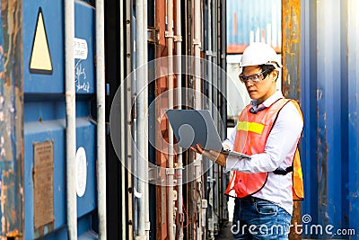 Import and export concept. Fore man shipper using tablet and computer laptop to monitor container and seal number status at Stock Photo