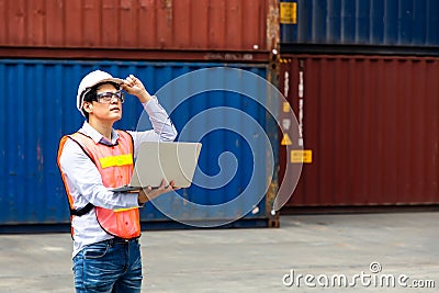 Import and export concept. Fore man shipper using tablet and computer laptop to monitor container and seal number status at Stock Photo