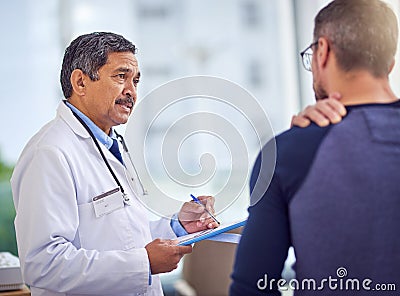 It is important that you take it easy from now on. a confident mature male doctor doing a checkup on a patient while Stock Photo