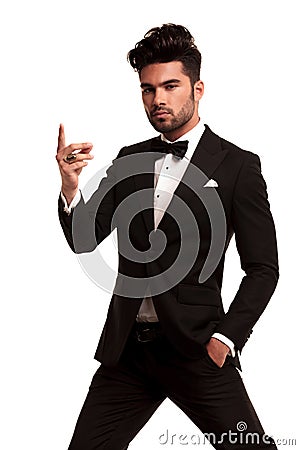 Imposing fashion man in tuxedo snapping his fingers Stock Photo