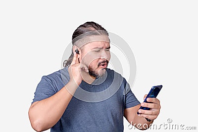 An impressed man listening to some sick tunes on his streaming app on his phone connected to bluetooth earphones. Isolated on a Stock Photo