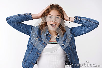 Impressed surprised excited cute redhead girl cannot believe she won lottery touch head widen eyes astonished drop jaw Stock Photo