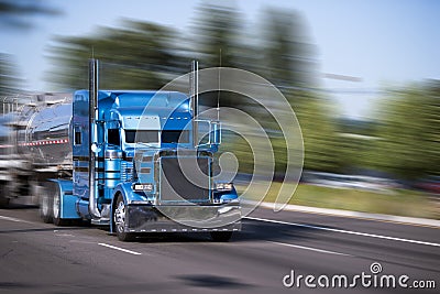 Impressive customized blue big rig semi truck with tank trailers Stock Photo