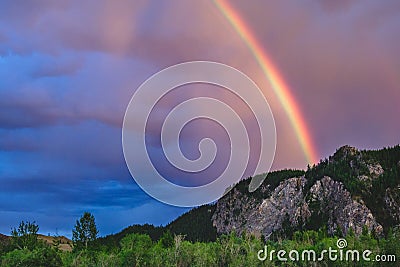 An impressive rainbow over a mountain range in Kuray steppe of Altai Krai Stock Photo