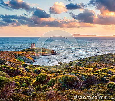 Impressive sunset view of Piscinni bay with Torre di Pixinni tower on background. Fantastic evening scene of Sardinia island, Ital Stock Photo