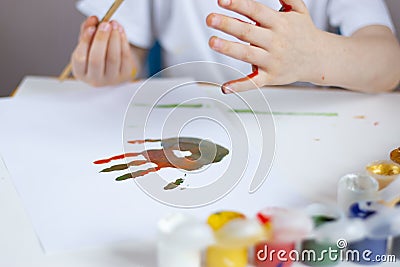 Imprint of a children`s palm stained with paints on white paper. Children`s creativity Stock Photo