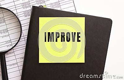 IMPROVE text on a sticker on your desktop. Diary and magnifier. Stock Photo