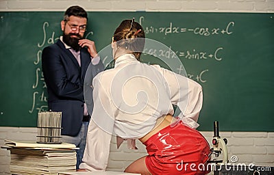 Impudent student. Flirting colleague. Girl sexy buttocks sit table. Everyone dreaming about such teacher. Lustful tutor Stock Photo