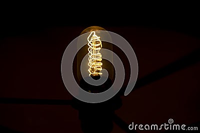 Incandescent lamp in dark. Light in interior. Hot wire. Glass flask Stock Photo