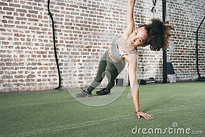 Include side planks in your core exercise routine. a sporty young woman doing the side plank at the gym. Stock Photo