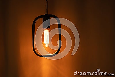 Included electric light bulb on the background of dark curtains, lamp Stock Photo