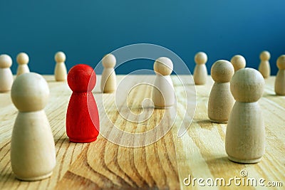 Inclusion social concept. Red figurine between wooden figurines Stock Photo