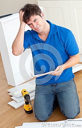 Incomprehensive man reading furniture instructions Stock Photo