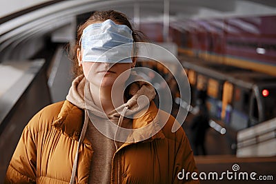 Incorrectly put on a mask on a woman in public transport among people Stock Photo