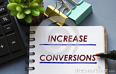 INCREASE CONVERSIONS words is written in a notebook with a marker, calculator, clamps and cactus Stock Photo