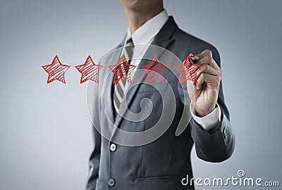 Increase rating, ranking, review, evaluation or classification concept. Businessman is drawing five red stars to increase rating Stock Photo