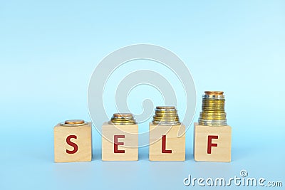 Increasing stack of coins with word self on wooden blocks in blue background. Invest on yourself improvement. Stock Photo