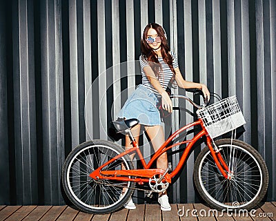 Incredible long-legged girl asian in a summer outfit, American sunglasses, cassette player and headphones posing with a Stock Photo