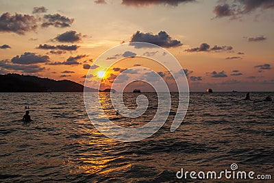 Incredibly picturesque landscape with a view of the waves in the ocean and the bronze sun at the golden hour at sunset in thailand Stock Photo