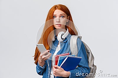 Indecisive, nervous cute redhead freshman girl, start new year college, looking worried camera, biting lip nervously Stock Photo