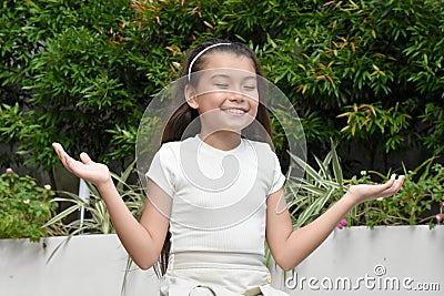 An Indecisive Philippina Female Kid Outside Stock Photo