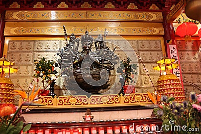 An indefinite sacred religious statue of a Chinese Buddhist temple. Bright colors and orange background Editorial Stock Photo