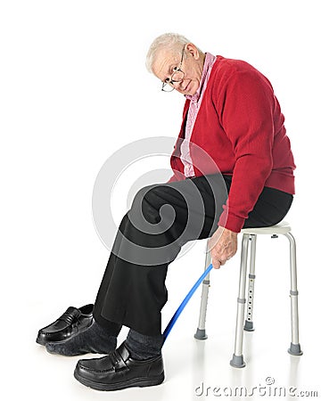 Independent Senior Using Assistive Dressing Device Stock Photo