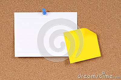 Office index card with post it style yellow sticky note pinned to cork board, copy space Stock Photo