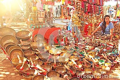 India, Goa. January 24, 2018. A woman sells Tibetan singing bowls made of golden bronze Editorial Stock Photo