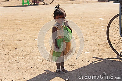 India, Hampi, 02 February 2018. A little poor girl in a dirty dress. Portrait of an indian girl. A girl from India in ornaments Editorial Stock Photo