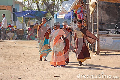 India, Hampi, 02 February 2018. Women in bright saris walk down the street and smile. Indian women Editorial Stock Photo
